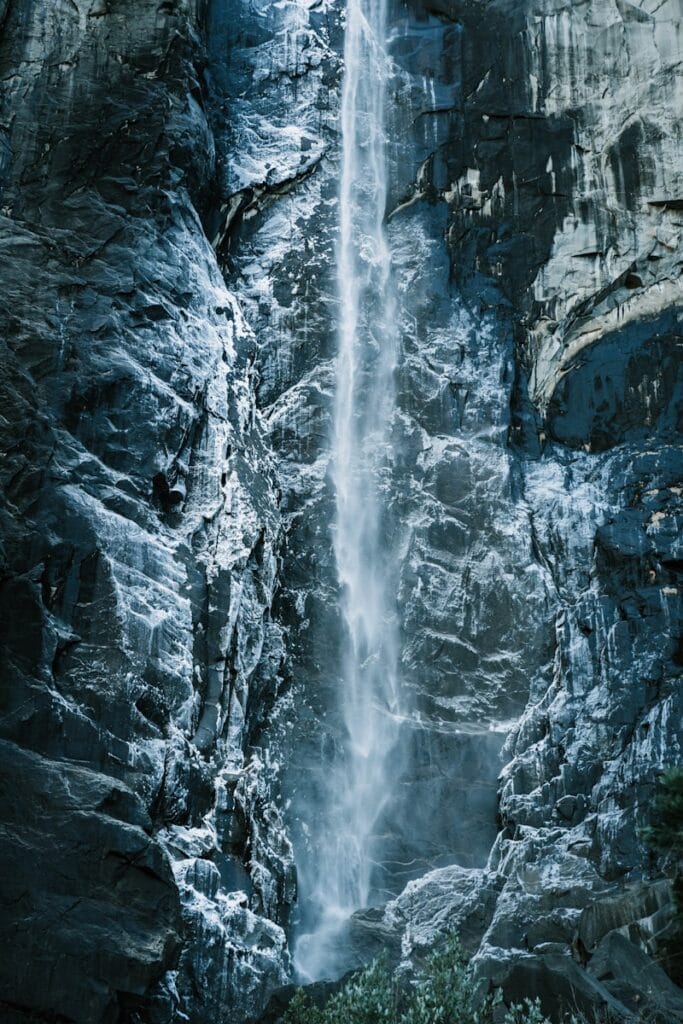 A large waterfall is in the middle of a mountain