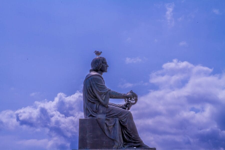 a statue of a man sitting on top of a bench
